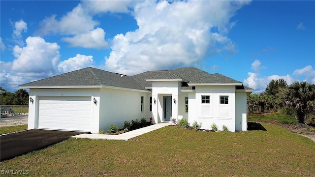 prairie-style home featuring a front lawn and a garage