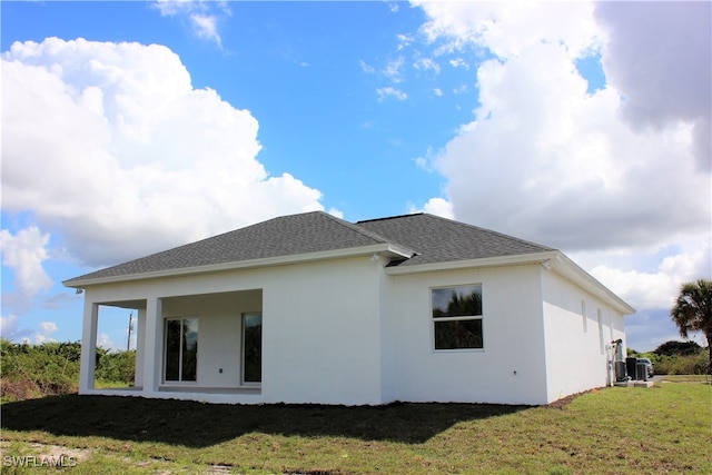 back of house featuring central AC and a yard