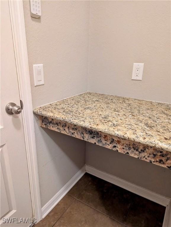 interior details featuring built in desk and baseboards