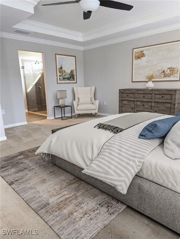 bedroom featuring ensuite bathroom, carpet floors, ceiling fan, a raised ceiling, and crown molding