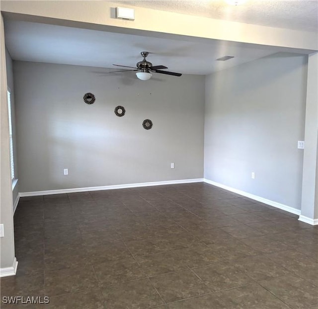 spare room featuring visible vents, ceiling fan, and baseboards