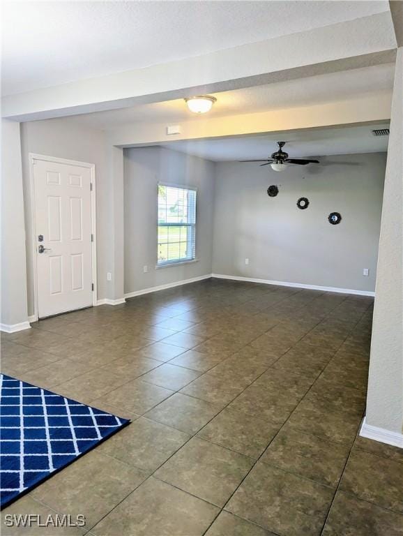 spare room featuring dark tile patterned floors and ceiling fan