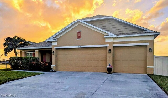 view of front of house with a garage, concrete driveway, and stucco siding