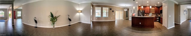 kitchen with stainless steel refrigerator with ice dispenser, a healthy amount of sunlight, hanging light fixtures, and dark tile patterned floors