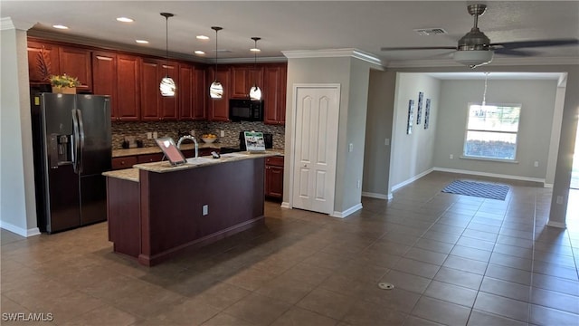 kitchen featuring refrigerator with ice dispenser, crown molding, backsplash, light stone counters, and a center island with sink