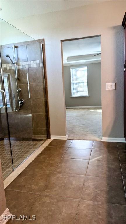 full bathroom featuring baseboards, a stall shower, and tile patterned floors