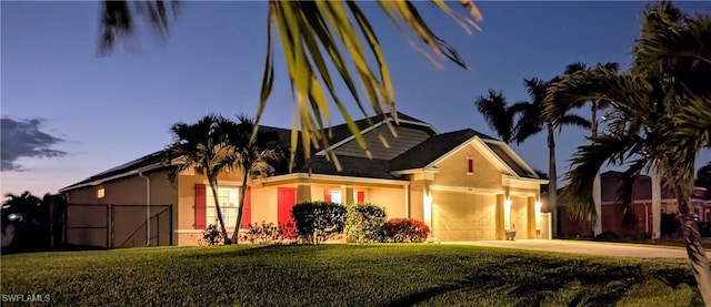 view of front of property featuring a garage, concrete driveway, a front yard, and stucco siding