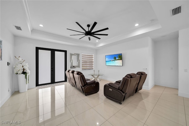 living room with crown molding, a raised ceiling, light tile patterned floors, and ceiling fan