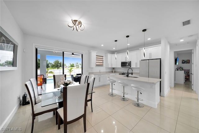 dining area featuring light tile patterned flooring, sink, ceiling fan, and a wealth of natural light