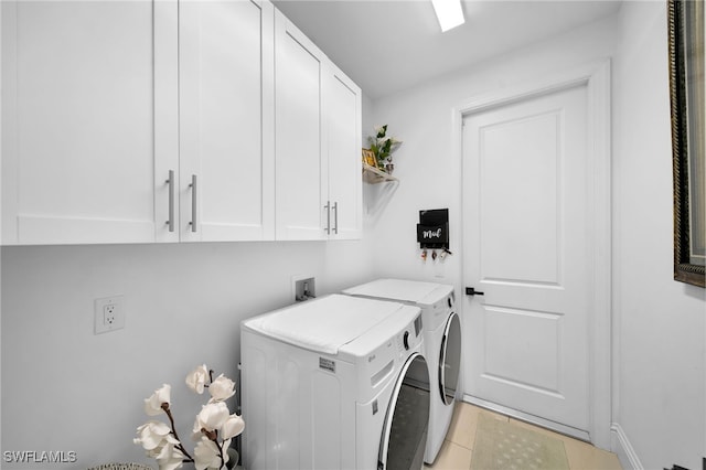 laundry room with washer and clothes dryer, light tile patterned floors, and cabinets