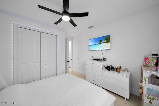 tiled bedroom featuring ceiling fan and a closet