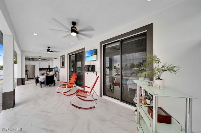 sitting room featuring ceiling fan and a textured ceiling