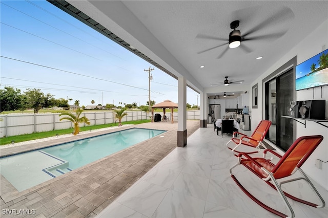 view of pool with a patio and ceiling fan