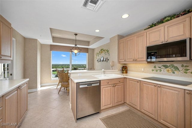 kitchen with sink, hanging light fixtures, a raised ceiling, kitchen peninsula, and stainless steel appliances