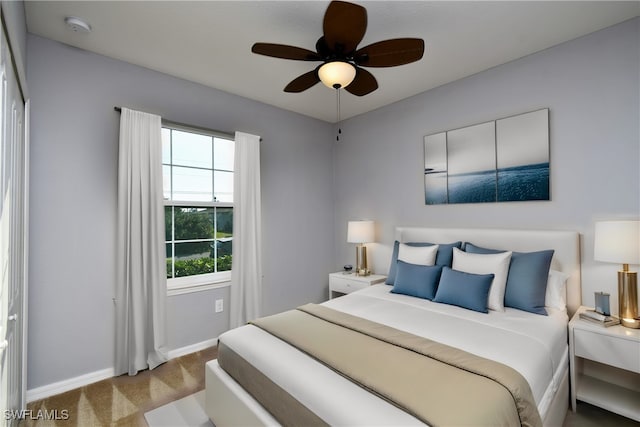 bedroom with ceiling fan and light colored carpet