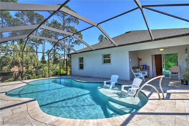 view of swimming pool with glass enclosure and a patio area