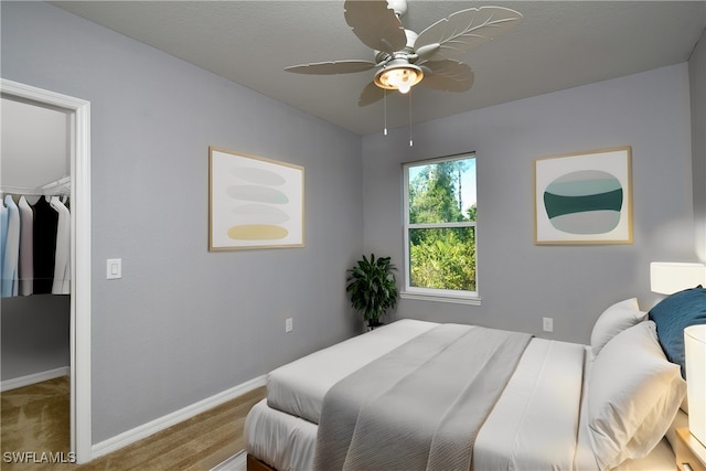 bedroom featuring carpet flooring, a spacious closet, ceiling fan, and a closet