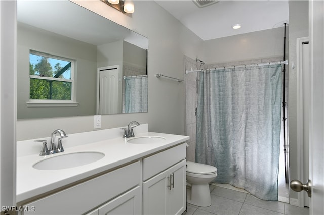 bathroom with tile patterned flooring, walk in shower, vanity, and toilet