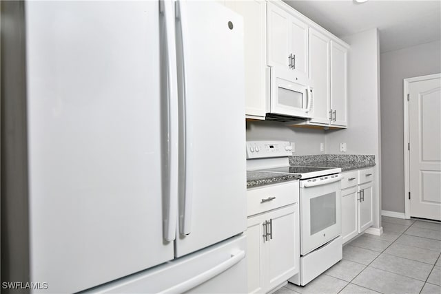 kitchen with light tile patterned flooring, white appliances, and white cabinetry