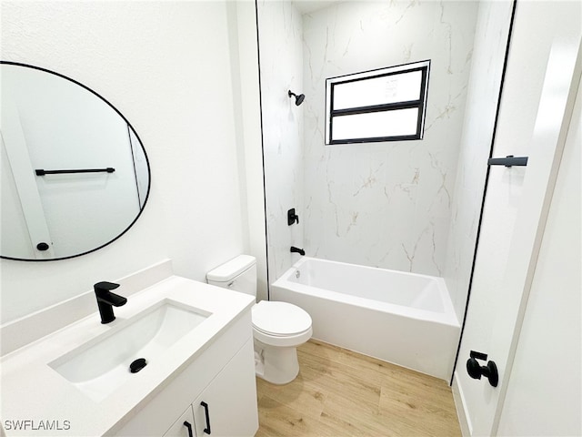 full bathroom with hardwood / wood-style floors, tiled shower / bath, vanity, and toilet