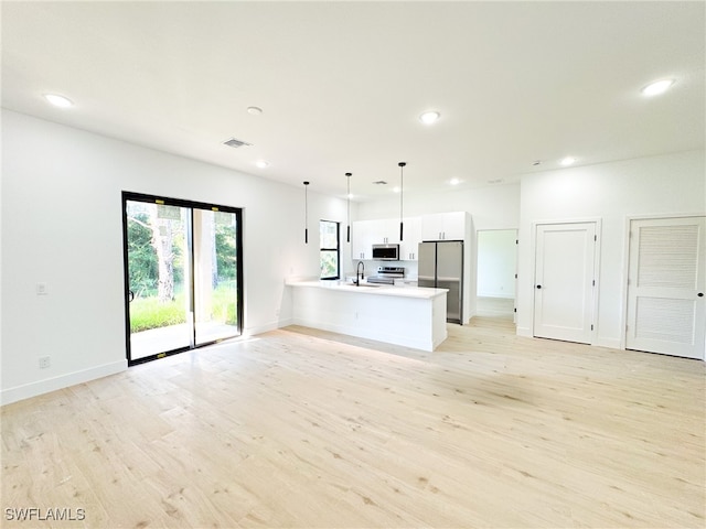 unfurnished living room with light hardwood / wood-style flooring and sink