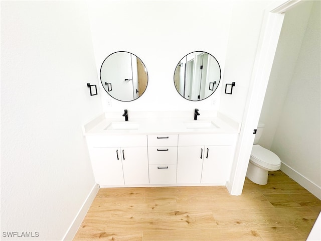 bathroom with vanity, hardwood / wood-style floors, and toilet