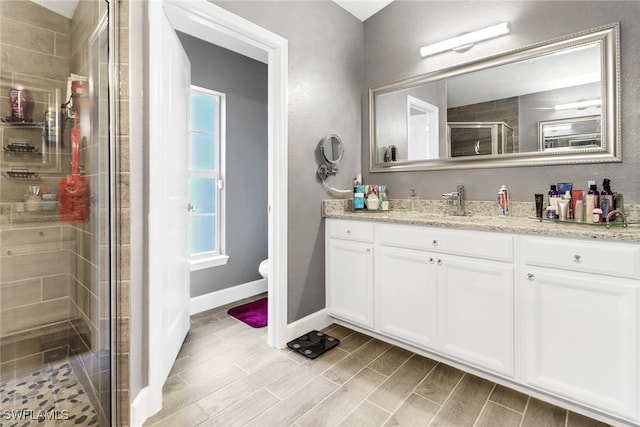 bathroom featuring walk in shower, vanity, and toilet