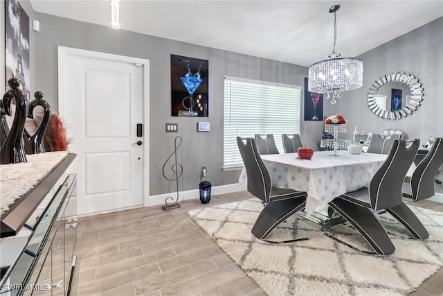 dining space with an inviting chandelier and light hardwood / wood-style flooring