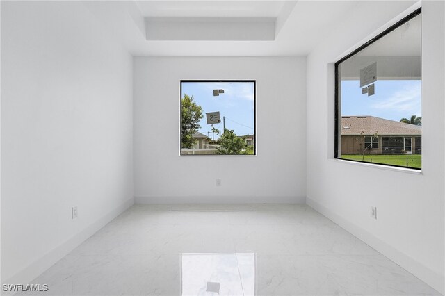 unfurnished room featuring a tray ceiling