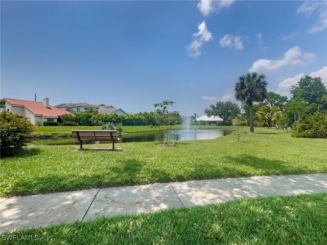 surrounding community with a lawn and a water view