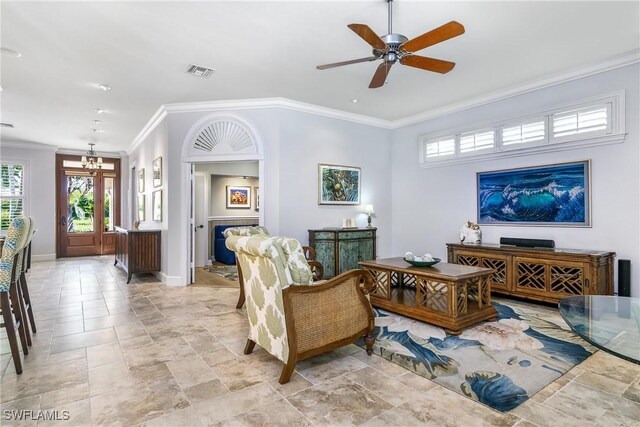 living room with crown molding and ceiling fan with notable chandelier