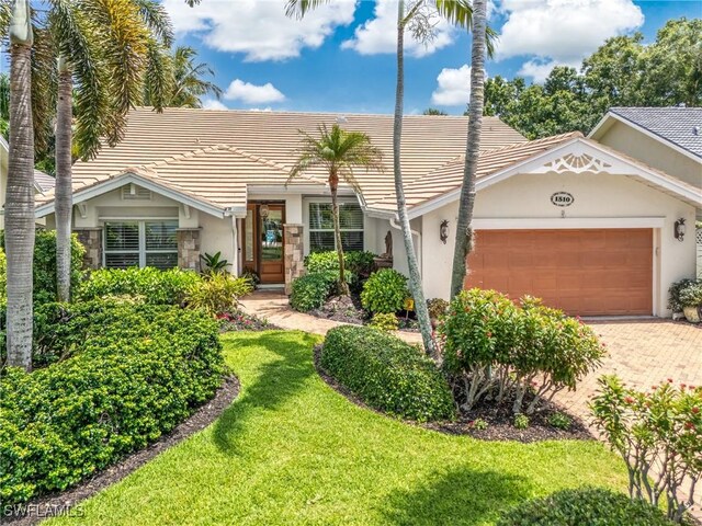 ranch-style house with a garage and a front lawn