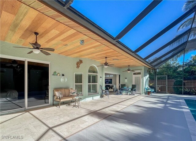 view of patio / terrace with ceiling fan and a lanai