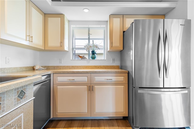 kitchen featuring light wood-type flooring, light brown cabinets, and stainless steel appliances