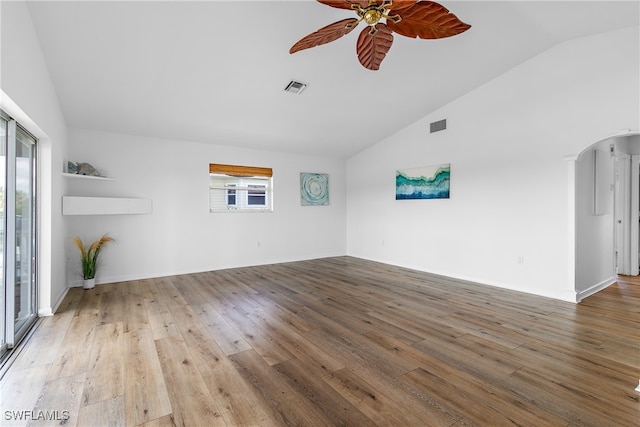 empty room with wood-type flooring, vaulted ceiling, and plenty of natural light