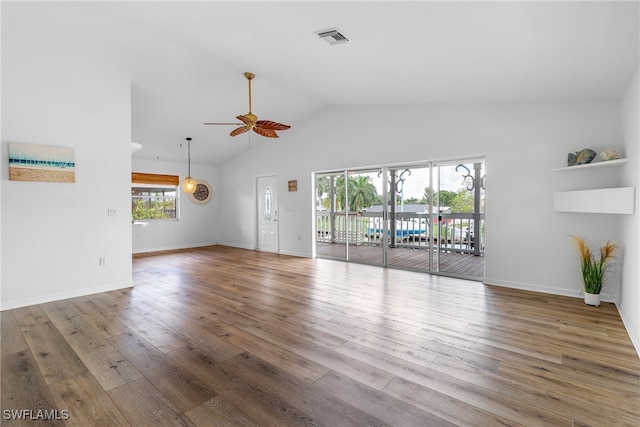 unfurnished living room featuring a wealth of natural light, vaulted ceiling, wood-type flooring, and ceiling fan