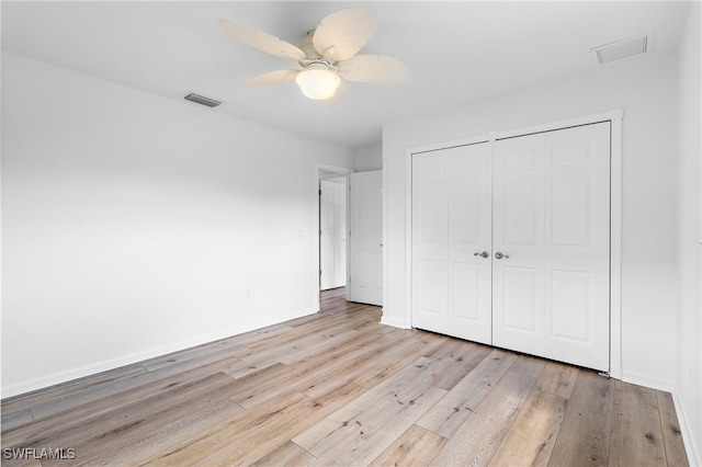 unfurnished bedroom featuring ceiling fan, light hardwood / wood-style flooring, and a closet