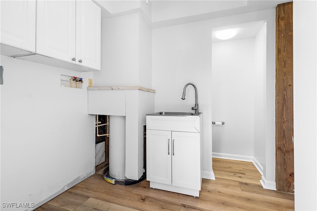 washroom with hookup for a washing machine, cabinets, light hardwood / wood-style flooring, and sink