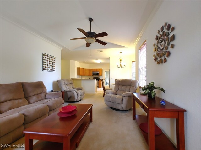 carpeted living room featuring ceiling fan with notable chandelier, lofted ceiling, and ornamental molding