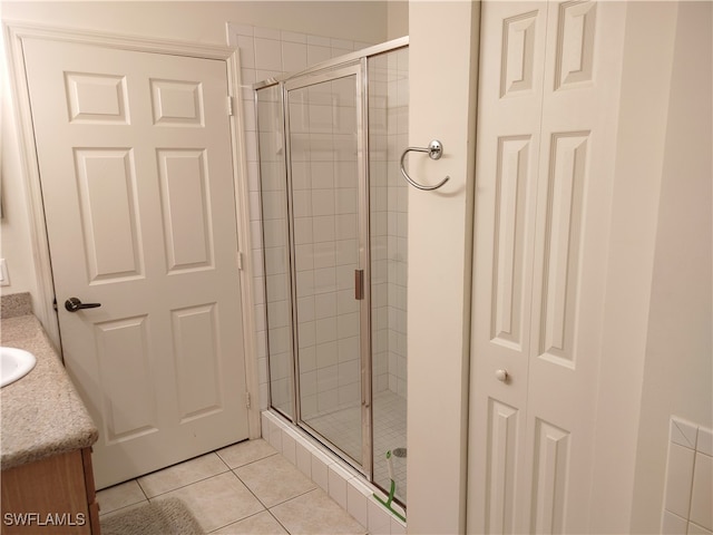 bathroom with tile patterned flooring, vanity, and a shower with door