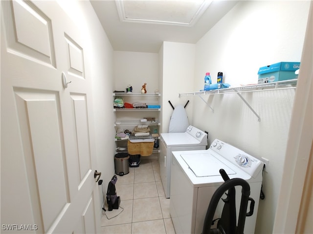 clothes washing area with light tile patterned floors and independent washer and dryer