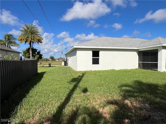 view of yard featuring a sunroom and fence