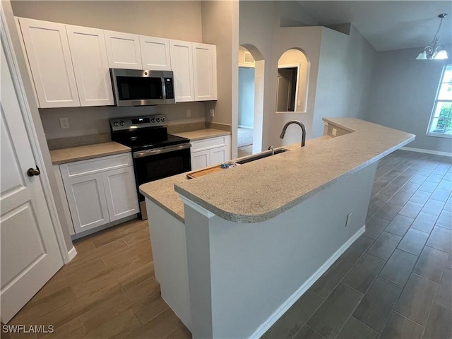 kitchen featuring wood finish floors, white cabinets, stainless steel microwave, and black electric range oven