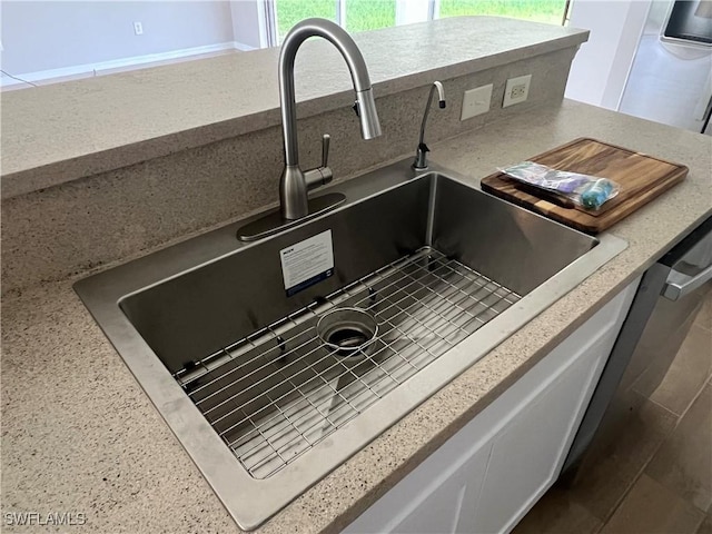 interior details featuring tasteful backsplash, sink, and stainless steel dishwasher