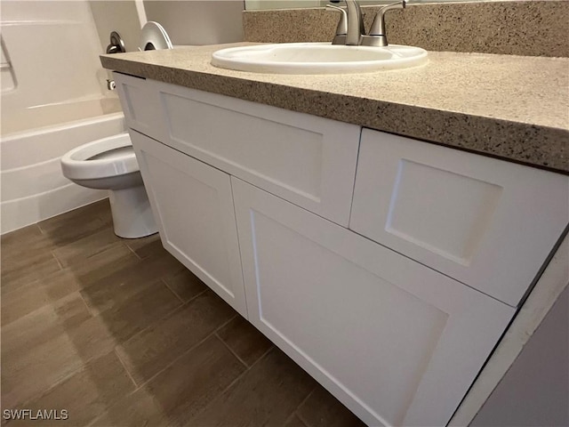 bathroom with wood tiled floor, vanity, and toilet