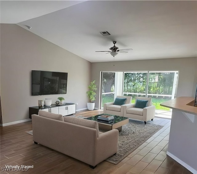 living room featuring ceiling fan and vaulted ceiling