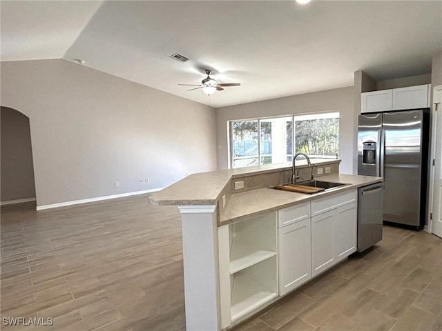 kitchen featuring visible vents, open floor plan, a kitchen island with sink, stainless steel appliances, and a sink