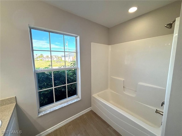 bathroom featuring baseboards, shower / bathtub combination, wood finished floors, vanity, and recessed lighting