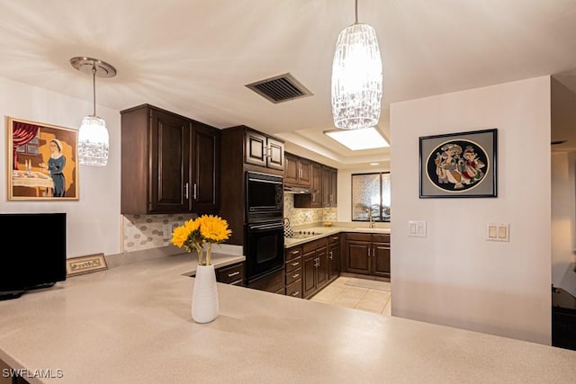 kitchen with pendant lighting, dark brown cabinets, and black appliances