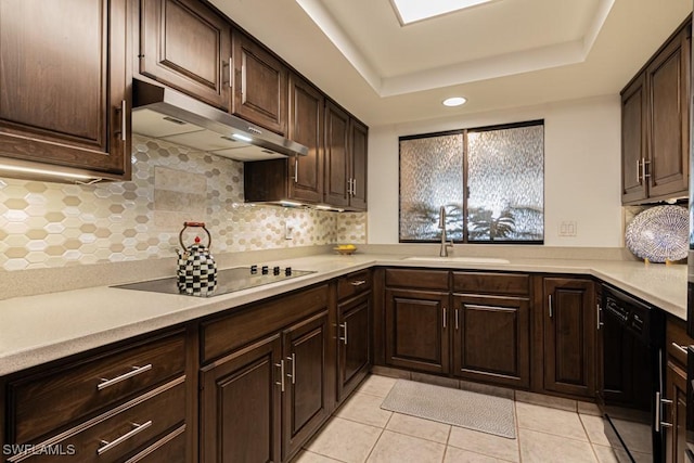 kitchen with sink, backsplash, dark brown cabinetry, black appliances, and a raised ceiling